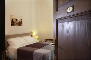 a bedroom with a bed and a wooden door at Villa Astoria in Taormina