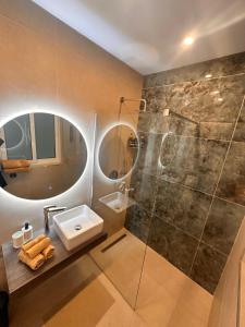 a bathroom with a sink and a glass shower at Desibu Collection - The Pearl St Julian's in St Julian's