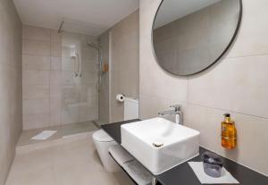 レックリングハウゼンにあるAspire Palais Recklinghausen, Trademark Collection by Wyndhamの洗面台と鏡のある白いバスルーム +61枚の写真