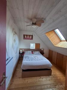 a bedroom with a bed and a ceiling fan at Les Roses Des Bois in Murat-le-Quaire