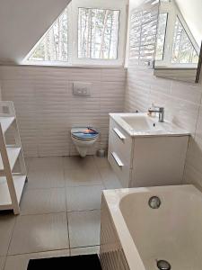 a white bathroom with a toilet and a sink at Villa Alex in Siófok +19 photos