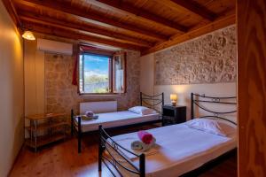 a bedroom with two beds and a window at Katouna Stone House in Katouna