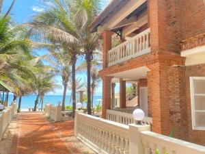 a brick house with palm trees on the beach at Kega Lighthouse Beach Resort in Ke Ga