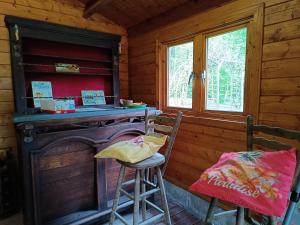 a kitchen with a stove and two stools in a cabin at bois de biron - gîte - vakantiehuis - chalet in Érezée