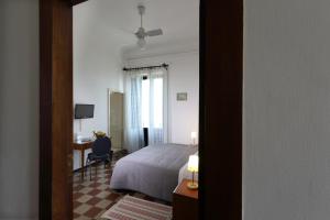 a bedroom with a bed and a desk with a desk at Villa Astoria in Taormina
