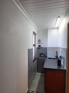 a kitchen with white walls and a counter top at Nature's View - Dana Bay in Mossel Bay +7 photos