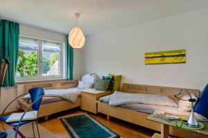 a bedroom with two beds and a table and a window at Bodenseenahe ruhige Ferienoase in Uhldingen-Mühlhofen