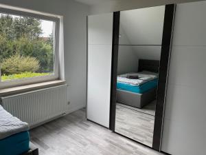 a mirror in a room with a bed and a window at Eastside-Apartment WHG 01 in Senftenberg