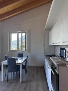 a kitchen and dining room with a table and chairs at Appartamento Riflessi D'Acqua in Navene