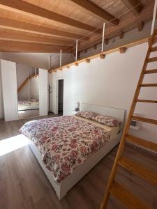 a bedroom with a large bed and a ladder at Appartamento Riflessi D'Acqua in Navene