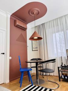 a dining room with a black table and blue chairs at Cosy hill in Kaunas