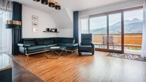 a living room with a couch and a chair at Sywarne, Sun & Snow in Kościelisko