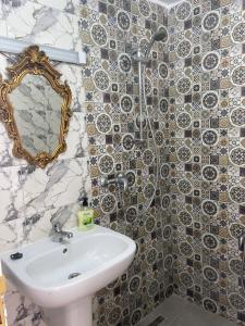 a bathroom with a sink and a shower with a mirror at Maison Fleur in La Goulette