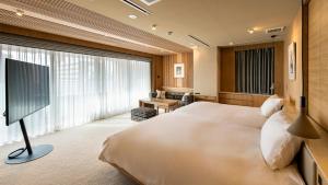 a hotel room with a bed and a television at TERRACE HOTEL f Shinosaka in Osaka