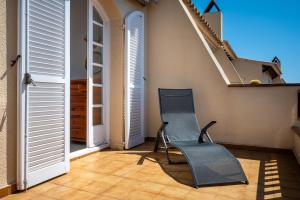 a balcony with a chair and a stair case at AT309 Con piscina a 5min playa in Altafulla