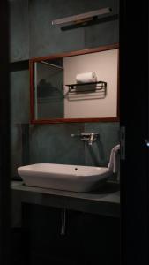 ein weißes Waschbecken in einem Badezimmer mit einem Spiegel in der Unterkunft Waterwoods Boutique Resort & Villas Havelock in Havelock Island + 6 Fotos