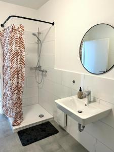 a bathroom with a sink and a shower with a mirror at Apartment über 3-Etagen genau im Zentrum! in Neumünster +13 photos