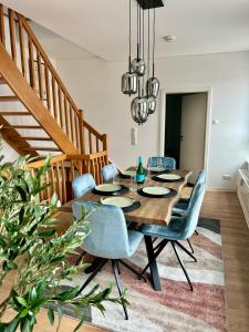 a dining room with a wooden table and blue chairs at Apartment über 3-Etagen genau im Zentrum! in Neumünster