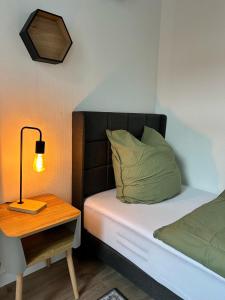 a small bedroom with a bed with a lamp and a table at Traumlage! 3-Etagen Apartment direkt im Zentrum in Neumünster