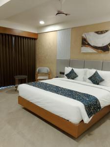a bedroom with a large bed in a room at The Blues Hotel in Chharodi
