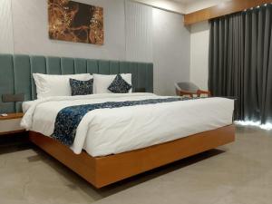 a bedroom with a large bed in a room at The Blues Hotel in Chharodi