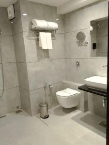 a bathroom with a toilet and a sink at The Blues Hotel in Chharodi