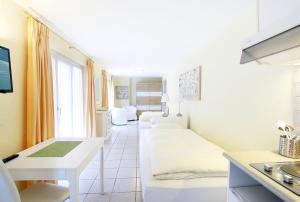 a room with two beds and a kitchen at Depandance Garni Golf in Ascona
