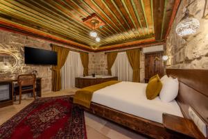 a bedroom with a bed and a television in a room at Latona Stone Palace in Nevsehir
