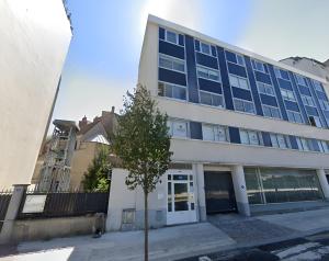a building with a tree in front of it at North Paris Suite in Paris