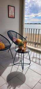 Un patio con dos sillas y una mesa con vista al mar. en Le Royal 180-degree view of the sea !, en Le Grau-du-Roi