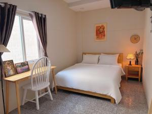 a bedroom with a bed and a desk and a window at Linh Ngọc Châu Hotel in Ho Chi Minh City