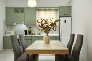 a kitchen with a table with a vase of flowers on it at El Dorado Corner with Hot Tub in Chania