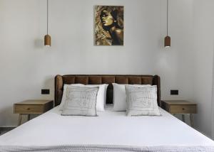 a bedroom with a bed with white sheets and pillows at D'Oliva, by ZanteWize in Zakynthos Town