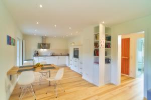 a kitchen with white cabinets and a table and chairs at Oberhausen an der Nahe LIEBLINGSORT - Ferienappartements in Oberhausen