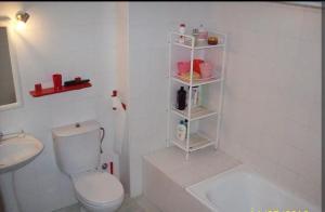 a white bathroom with a toilet and a sink at Spacious Apartment with Pool in El Rompido (178 m²) in El Rompido +11 photos