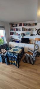 a living room with a table and a book shelf at Spacious Apartment with Pool in El Rompido (178 m²) in El Rompido