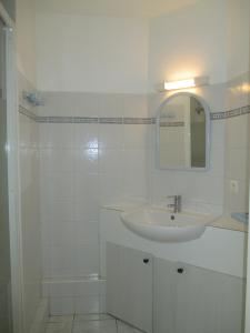 a white bathroom with a sink and a mirror at Appartement rénové 1 chambre ,rez de jardin,belle terrasse,proche plages,Carnac 2025-00427 in Carnac