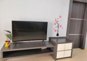 バトゥパハにあるJoyful Homestay Landed Houseのリビングの台上のテレビ