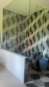 a bathroom with a shower with a mosaic wall at Rumah Malika in Munggu +7 photos