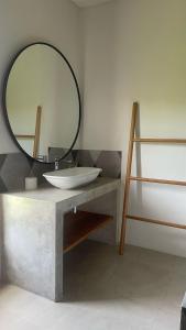 a bathroom with a sink and a mirror on a counter at Rumah Malika in Munggu