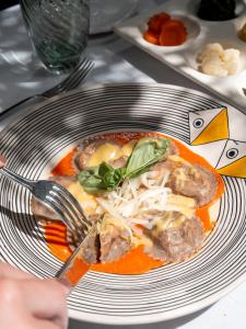 a person holding a fork and a plate of food at Boutique Hotel Casa Mariantonia in Anacapri