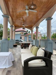 a couch on a patio with a wooden ceiling at La villa des anges in Kribi