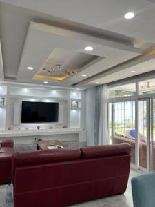 a living room with a couch and a flat screen tv at La villa des anges in Kribi