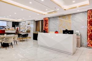 a lobby of a store with a white counter and chairs at Dancenter Bangkok Travellers Hotel in Bangkok