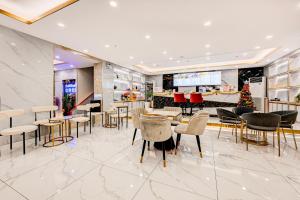 a lobby with tables and chairs and a christmas tree at Dancenter Bangkok Travellers Hotel in Bangkok