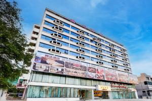 a tall building with advertisements on the side of it at Dancenter Bangkok Travellers Hotel in Bangkok