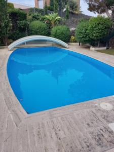 a large blue swimming pool with a curved roof at Villa Amparo con piscina privada in Calafell