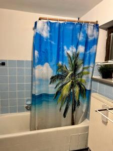 a bathroom with a shower curtain with a palm tree at Deine Pension, Double Room P1, 1-2 beds, 10qm, Check-in 4PM - 5AM in Creglingen +28 photos