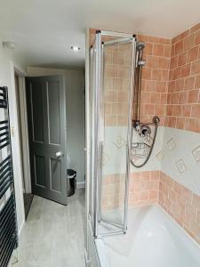 a shower with a glass door in a bathroom at Foundry Cottage in Portland +34 photos