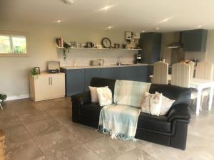 a living room with a couch and a kitchen at The Mole Hill in Bransford